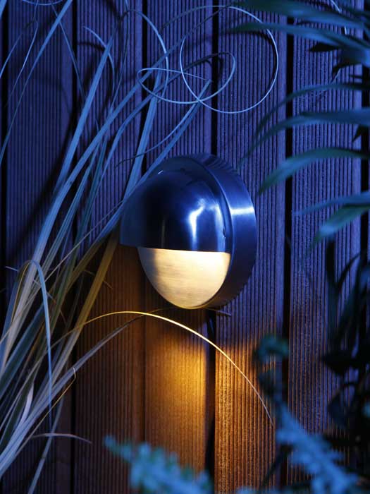 Wandleuchte Palm an einer Holzwand bei Nacht