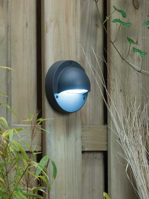 Anthrazite Wandleuchte Deimos an einem Holzzaun montiert